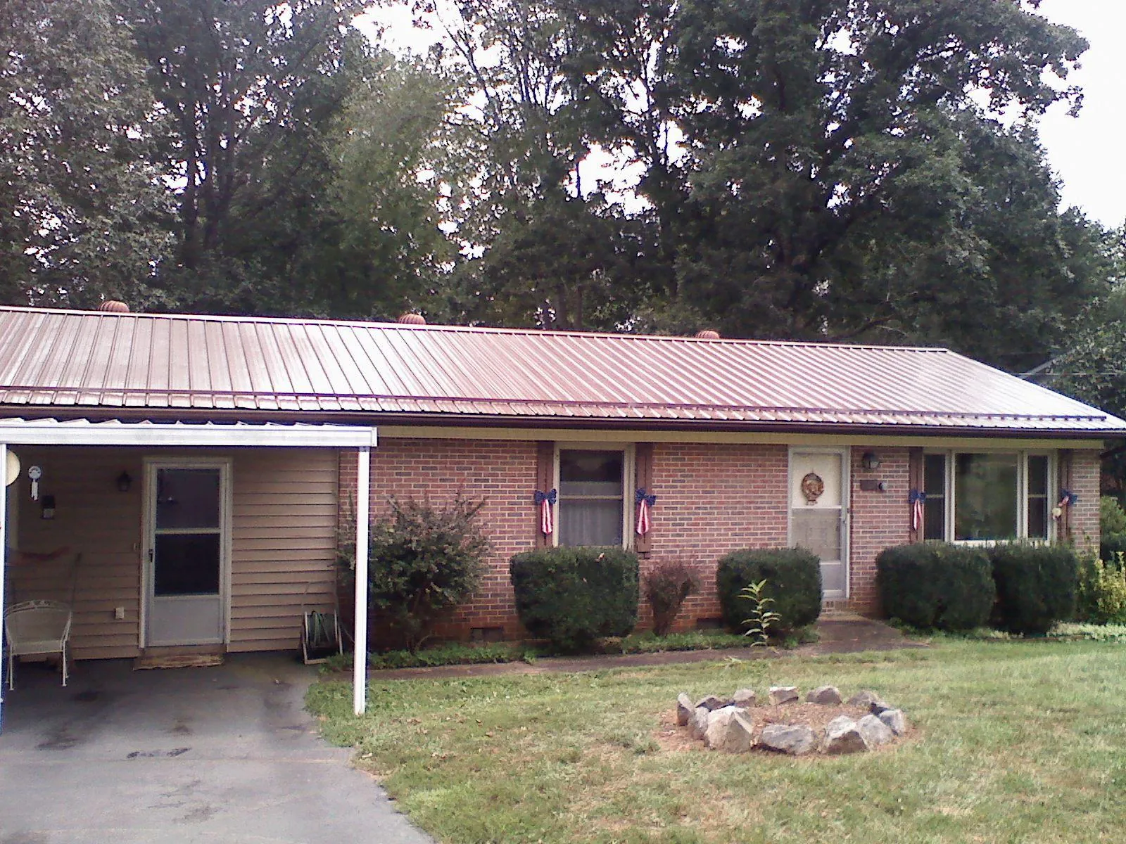 Bronze metal roof and carport on a brick ranch home — Roof Repair work by our crew in Lorida